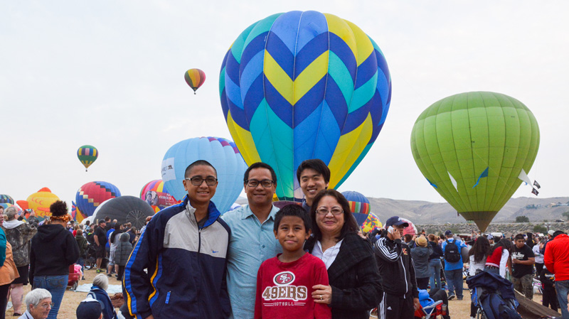 j-1 high school exchange student with host family in front of balloon